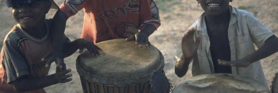 Kinder spielen auf der Djembe Trommel
